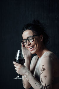 Portrait of a smiling young woman drinking glass