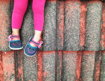 Low section of woman standing on footpath