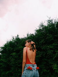 Low angle view of woman standing against plants