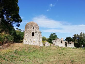 Old ruin building on field against sky