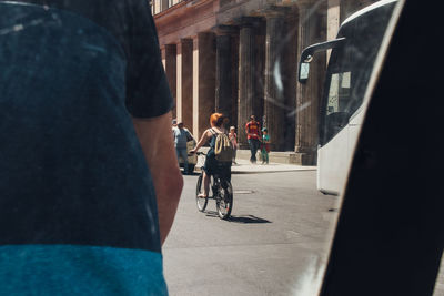 Rear view of people walking on street in city