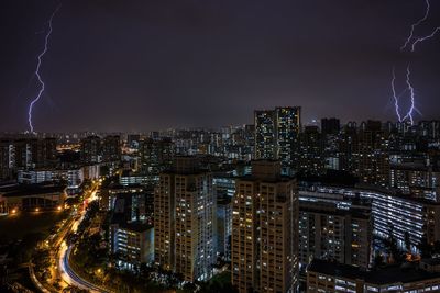 Illuminated cityscape against sky at night