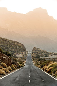 Empty road leading towards mountains