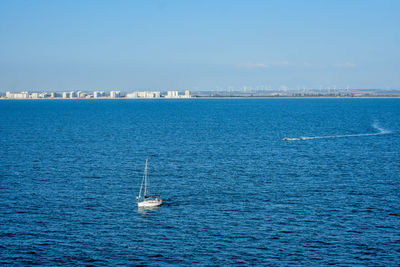 Sailboat sailing on sea against clear sky