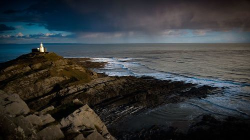 Scenic view of sea against cloudy sky during sunset