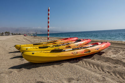 Deck chairs on beach against clear sky