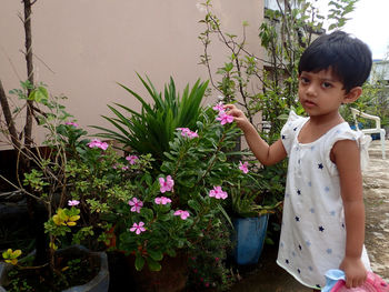 Little girl standing by flowering plants