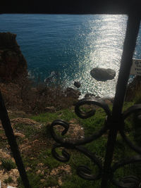 High angle view of sea seen through metal railing