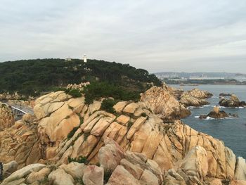 Scenic view of cliff by sea against sky