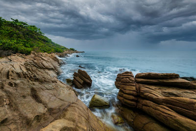 Rocks on sea shore against sky