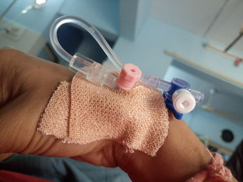 Cropped hand of man with iv drip in hospital