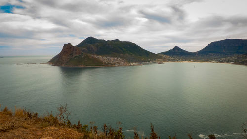 Scenic view of sea and mountains against sky