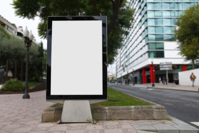 Empty road sign on footpath in city