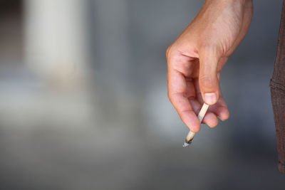 Close-up of hand holding cigarette