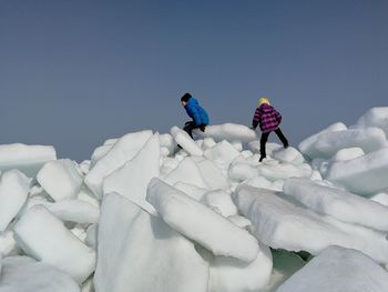 People on ice against sky