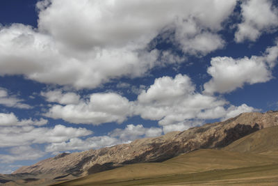 The beautiful barren alpine meadow under the blue sky and white clouds