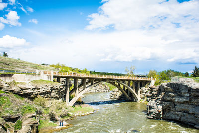 Arch bridge over river against sky