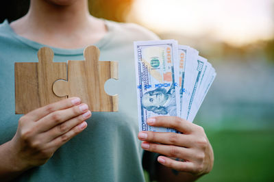 Midsection of woman holding paper currency