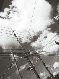 Low angle view of power lines against cloudy sky