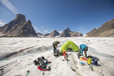 High angle view of people on snowcapped mountains against sky