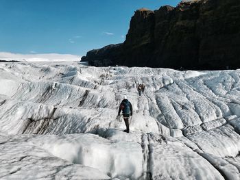 Full length of man on cliff against sky during winter