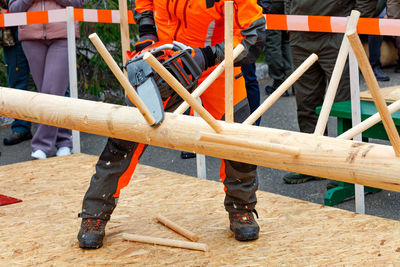 A worker demonstrates the skill of using chainsaw at the working site of the lumberjack competition