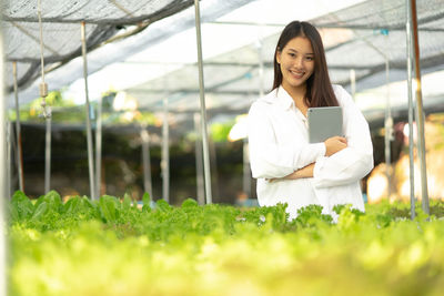 Portrait of young woman standing on grassy field