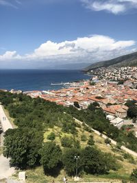 High angle view of townscape by sea against sky