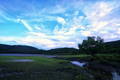 Scenic view of river and mountains against sky