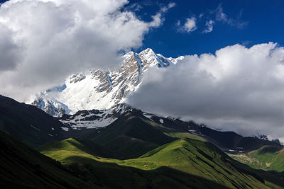 Scenic view of mountains against cloudy sky