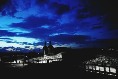 Silhouette built structure against blue sky