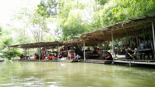 People in boat on canal against trees