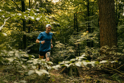 Full length of man running amidst plants