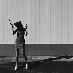 Rear view of woman standing against wall