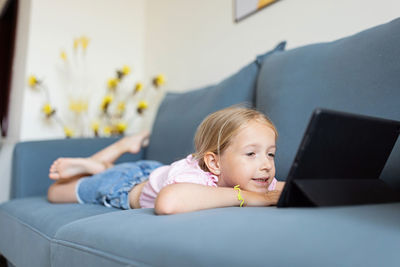 Portrait of cute baby boy sitting on sofa at home