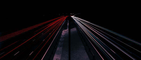 Illuminated suspension bridge against sky at night