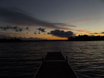 Pier on lake at sunset