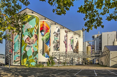 Graffiti on wall by building against sky