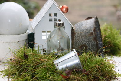 Close-up of damaged birdhouse and light bulb in yard