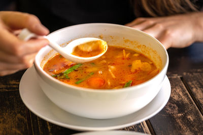 Midsection of person holding soup in bowl