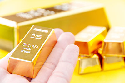 Close-up of hand holding gold bar