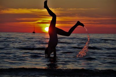 Full length of silhouette person on sea against sky during sunset
