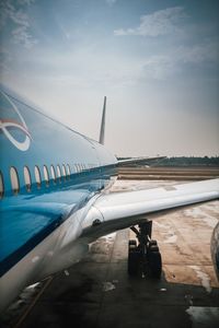 Airplane on airport runway against sky