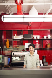 Portrait of businesswoman standing at office kitchen