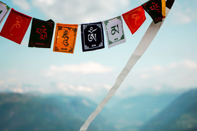 Low angle view of flags hanging against sky