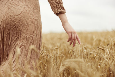 Low section of woman standing on field