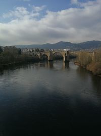 Arch bridge over river against sky