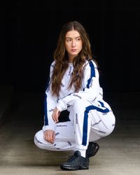Portrait of young woman sitting against black background