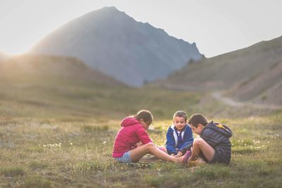 Girl sitting with friends on land