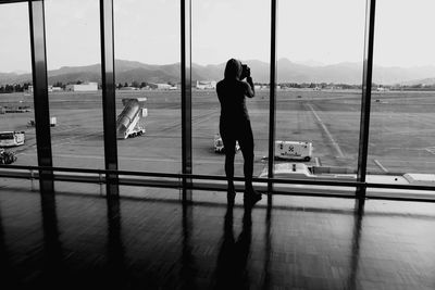 Full length of woman walking on airport window